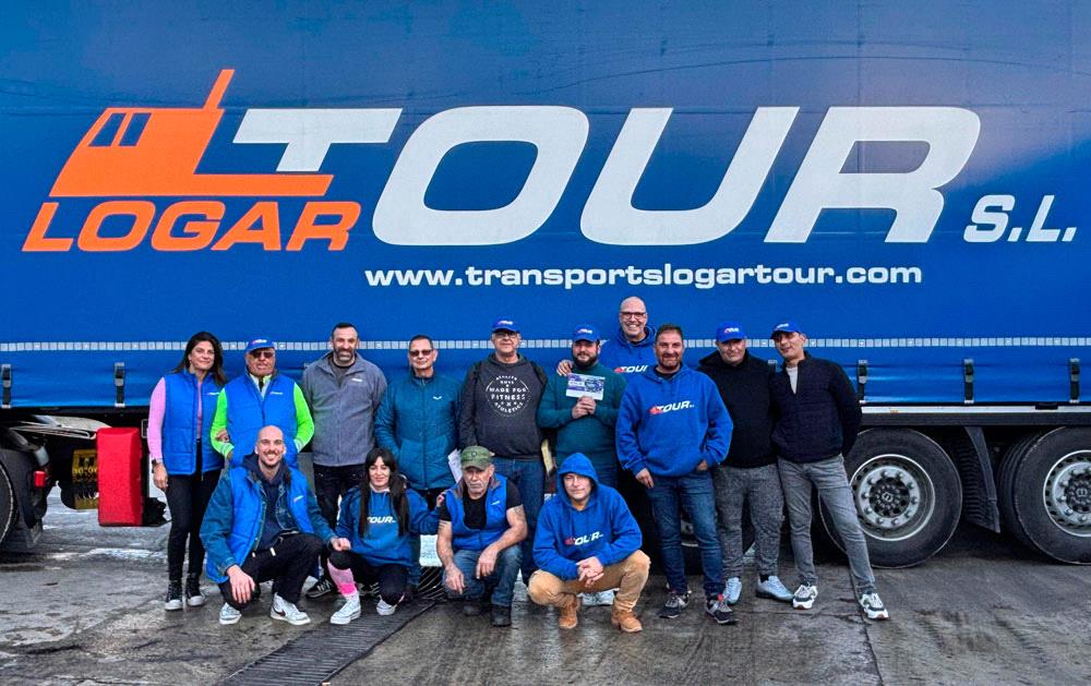 Fotografía grupal del equipo humano de Logartour S.L., incluidos conductores y personal de oficina, frente a un camión de la flota de la empresa.